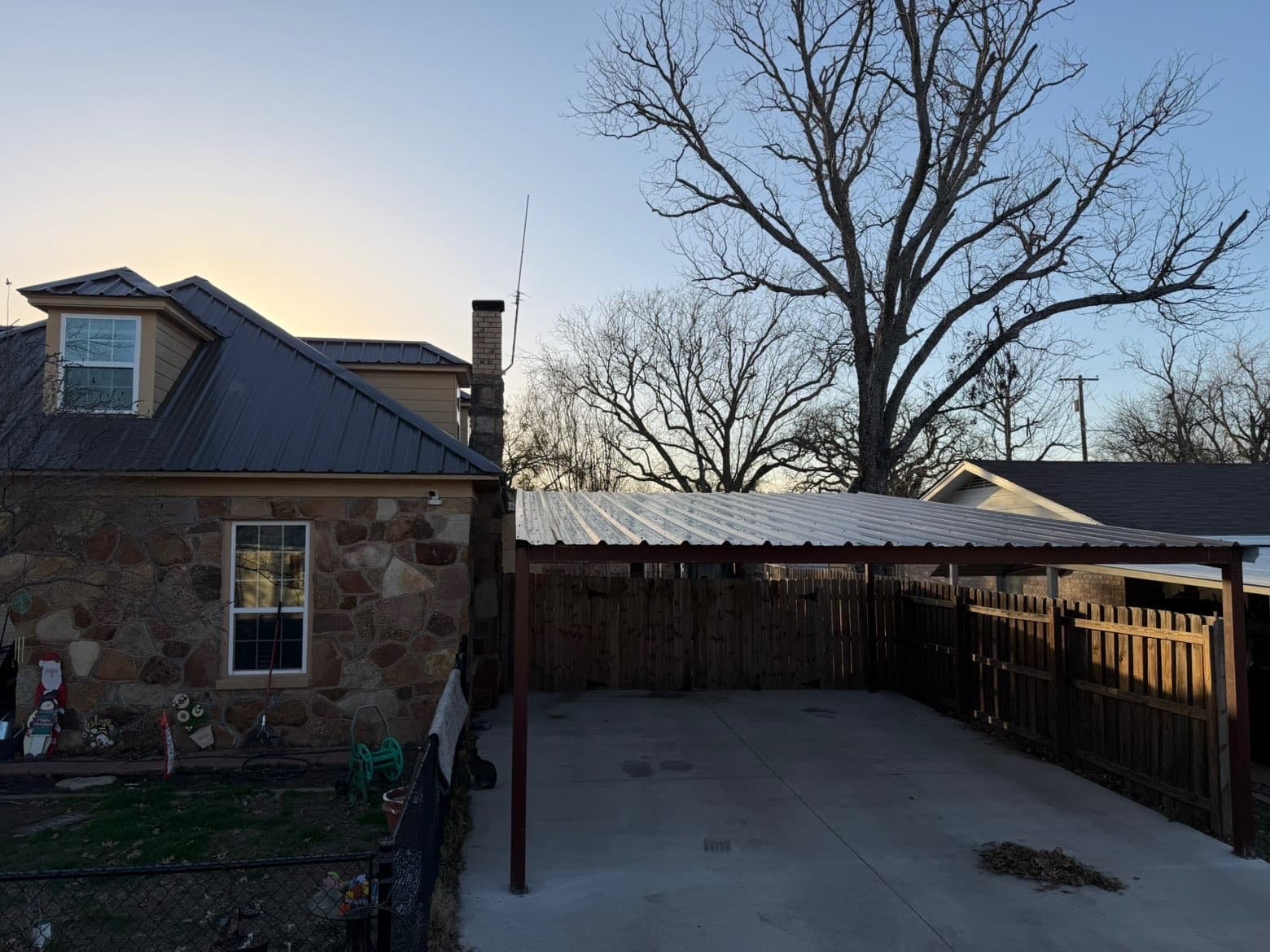 Residential metal carport cover over a concrete pad